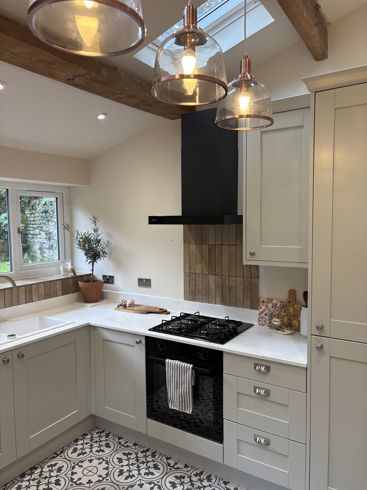 New kitchen hob, black extractor and tiled splashback with tall shaker cabinets