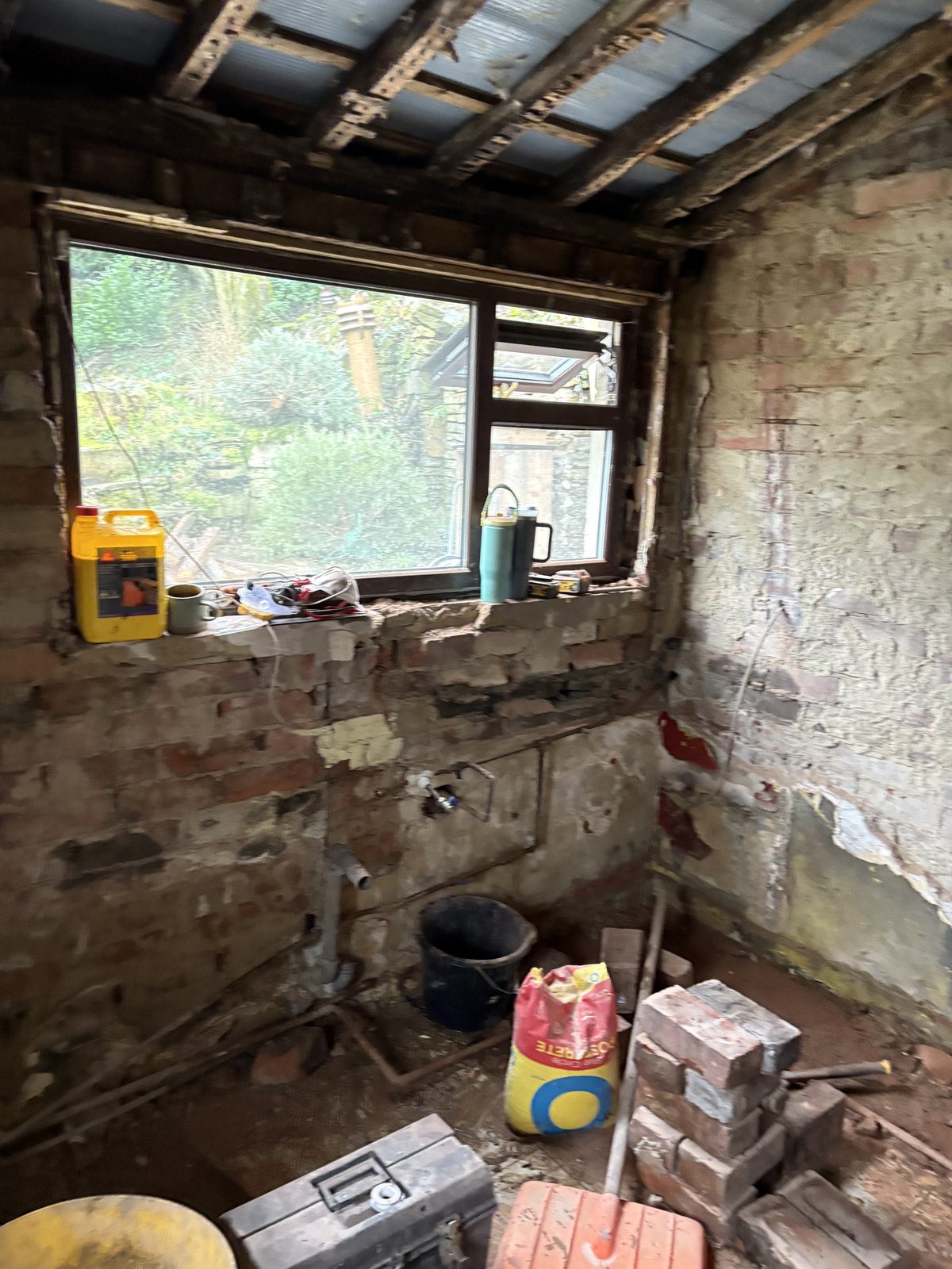 The room stripped back to brick and joists during the build