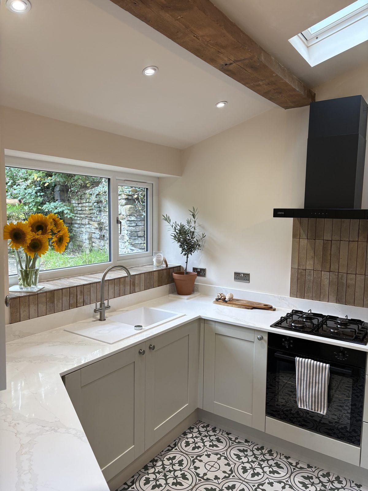 New kitchen sink and window with grey-green shaker cabinets and white worktops