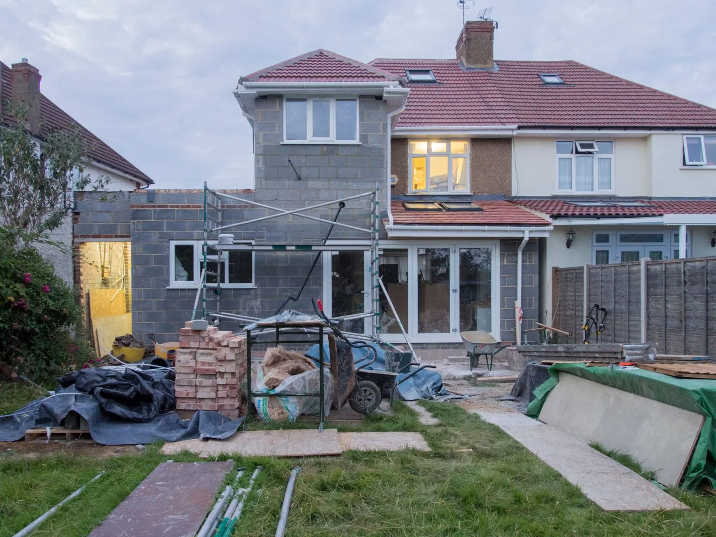 Home improvement project in West Yorkshire showing a modern brick extension with bifold doors at twilight